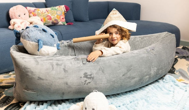 Child playing at being a pirate in sensory canoe