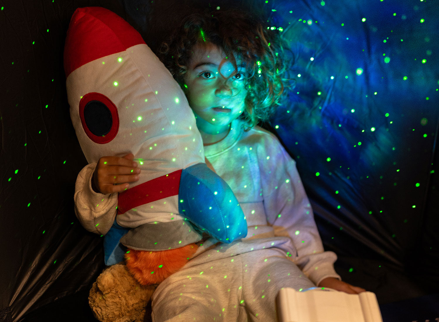 Boy relaxing with astronaut light projector
