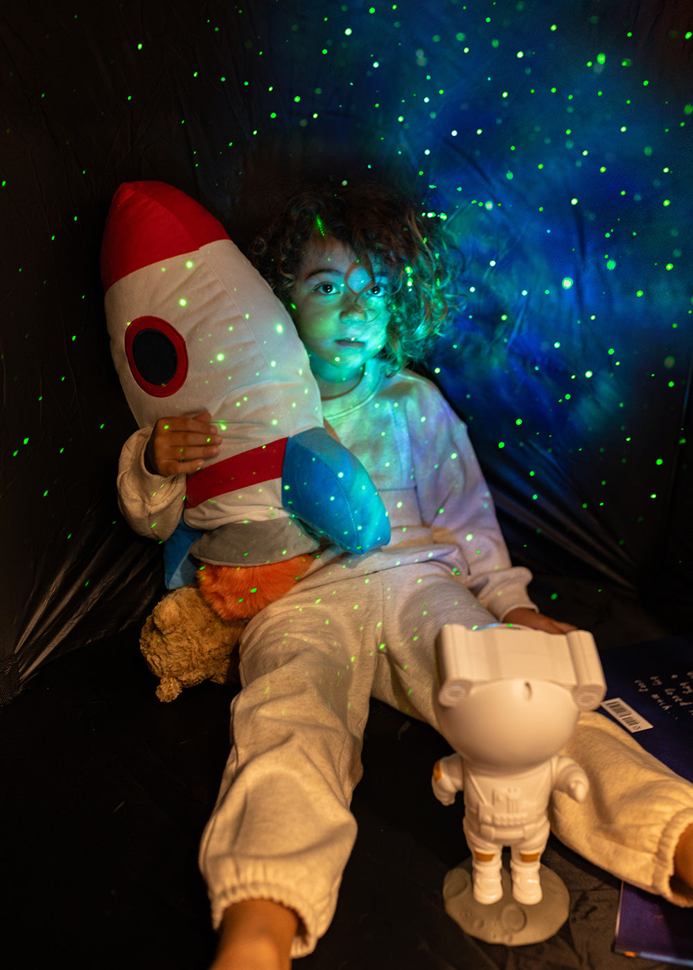 boy relaxing in astronaut light projector