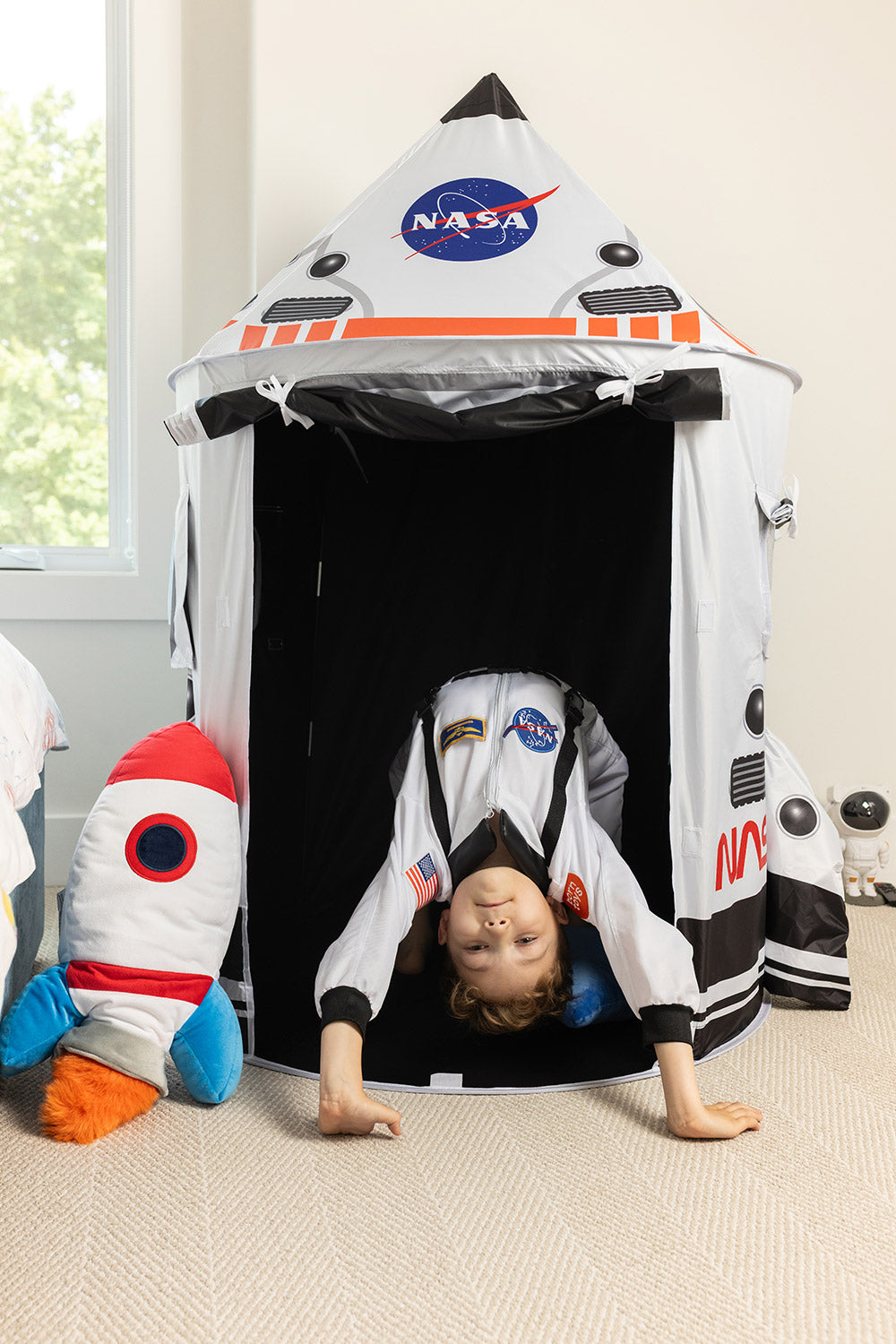 Boy dressed as astronaut in space tent